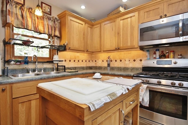 kitchen with tasteful backsplash, sink, stainless steel appliances, and decorative light fixtures