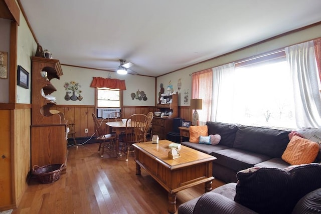 living room with wood-type flooring, cooling unit, ceiling fan, and wooden walls