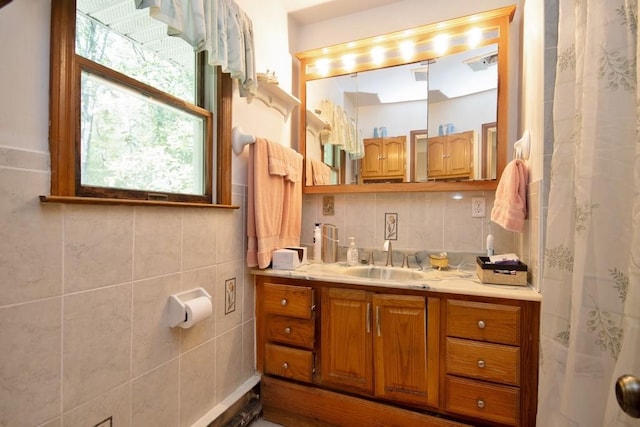 bathroom with a shower with shower curtain, vanity, and tasteful backsplash