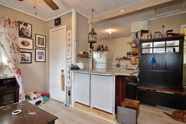 kitchen with light wood-type flooring, white refrigerator, white cabinetry, and light stone countertops