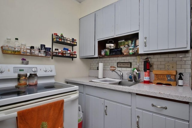 kitchen with white range with electric stovetop, tasteful backsplash, and sink