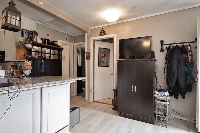 kitchen featuring light hardwood / wood-style floors, white cabinetry, and light stone counters