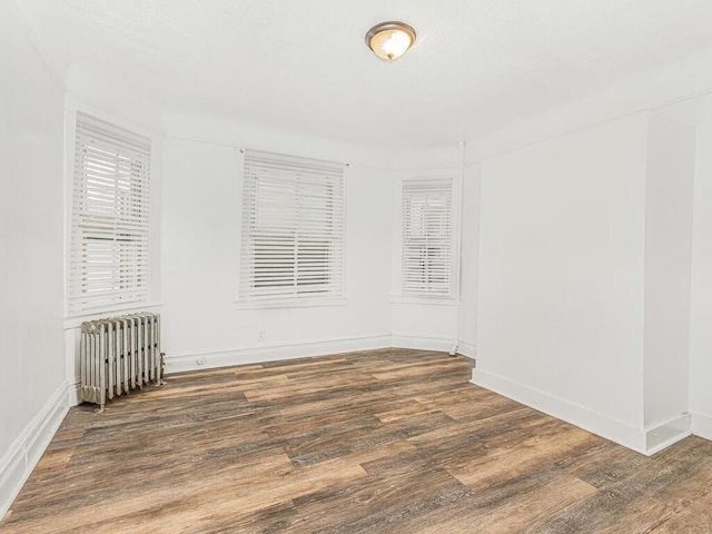 unfurnished room featuring dark wood-type flooring and radiator