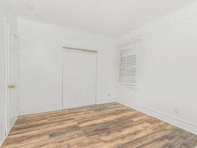 unfurnished bedroom with a closet and hardwood / wood-style flooring