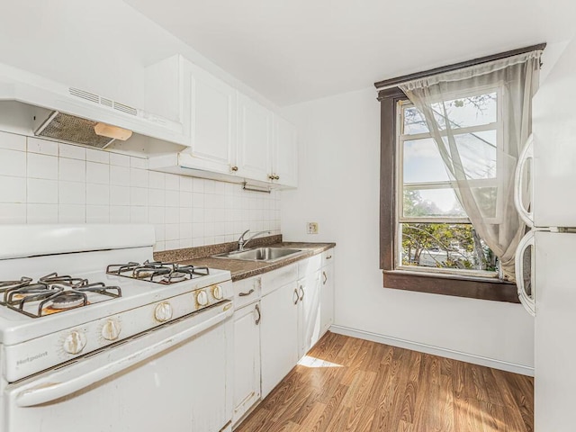 kitchen featuring sink, tasteful backsplash, light hardwood / wood-style floors, white appliances, and white cabinets