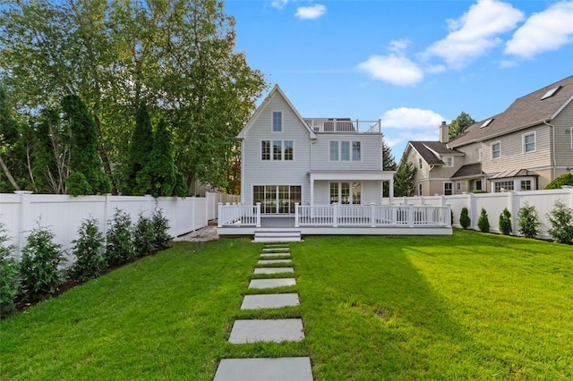 rear view of house featuring a lawn and a wooden deck