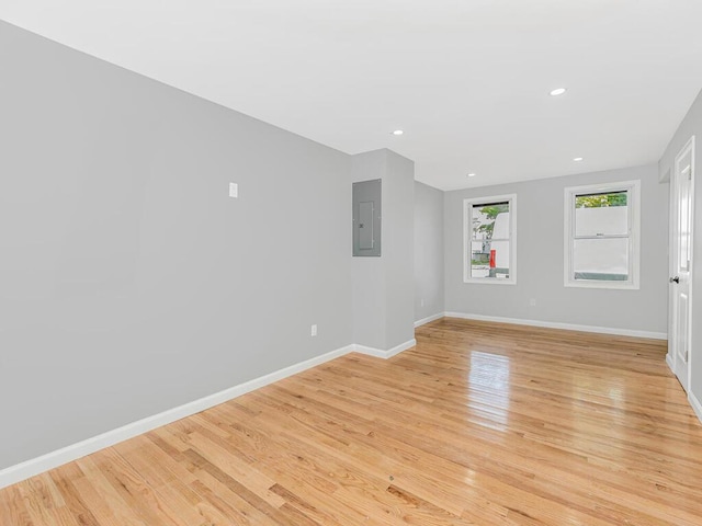 empty room featuring electric panel and light hardwood / wood-style flooring