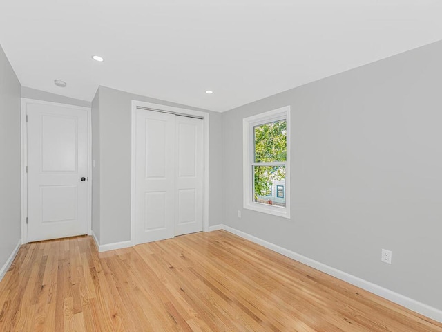 unfurnished bedroom with a closet and light hardwood / wood-style floors