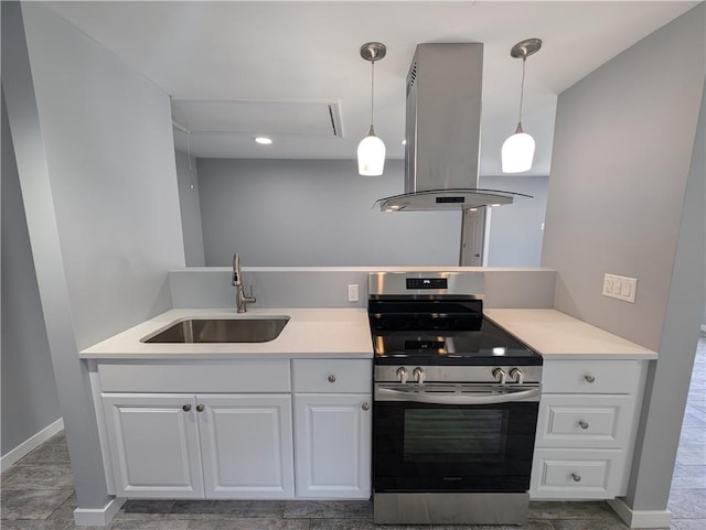 kitchen featuring stainless steel range, island range hood, sink, decorative light fixtures, and white cabinetry