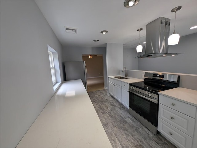 kitchen with dark wood-type flooring, sink, hanging light fixtures, island range hood, and stainless steel appliances