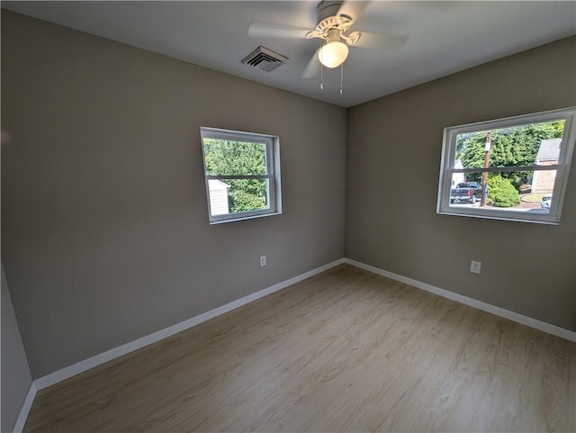 empty room with light wood-type flooring, plenty of natural light, and ceiling fan