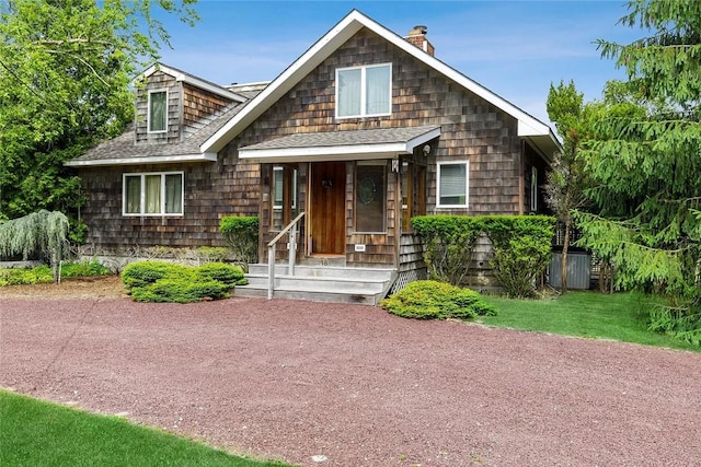 18 Brushy Neck Ln, Westhampton, NY 11977 - shingle-style home with a shingled roof, a chimney, and covered porch
