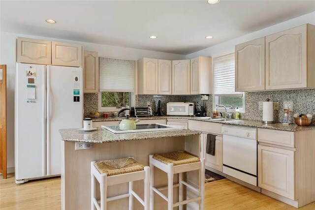 18 Brushy Neck Ln, Westhampton, NY 11977 - kitchen with white appliances, a sink, decorative backsplash, a breakfast bar area, and recessed lighting
