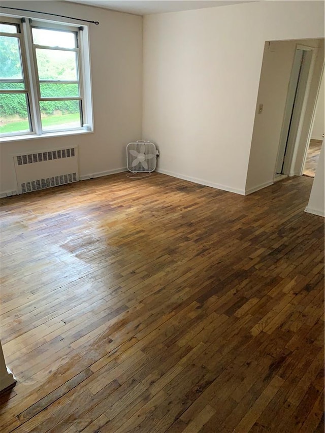 unfurnished room with dark wood-type flooring