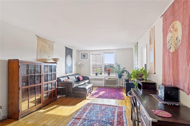 sitting room with radiator heating unit and light wood-type flooring