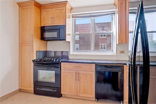 kitchen with black appliances, light brown cabinets, and light tile patterned floors