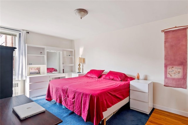 bedroom featuring wood-type flooring and radiator heating unit