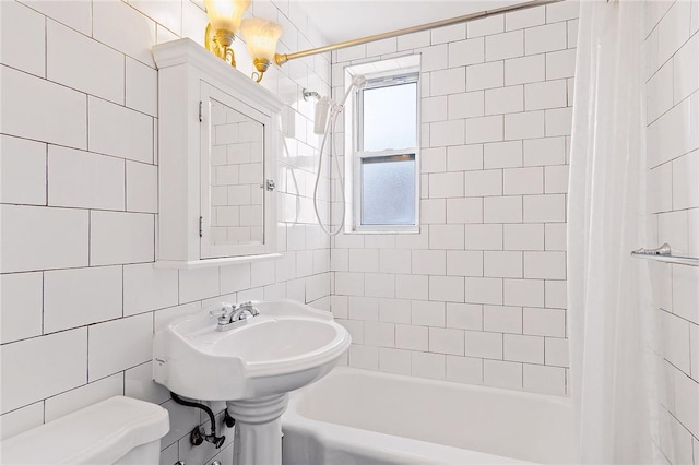 bathroom featuring shower / bathtub combination with curtain, toilet, and tile walls