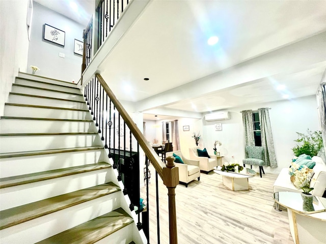 stairs with hardwood / wood-style floors and an AC wall unit