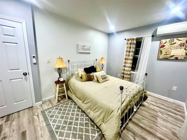 bedroom with wood-type flooring and an AC wall unit