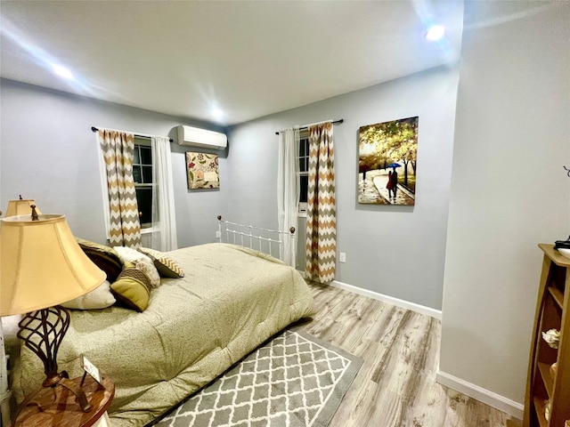 bedroom with wood-type flooring and a wall mounted AC