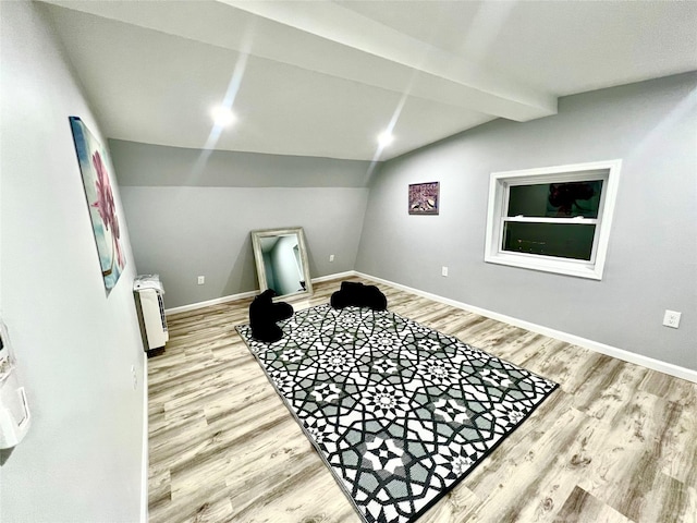 interior space with lofted ceiling with beams and hardwood / wood-style flooring