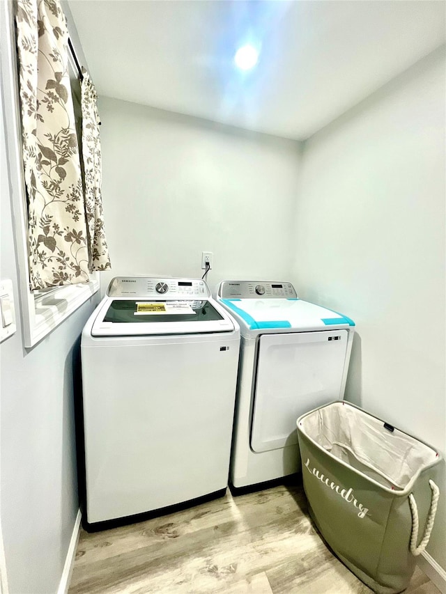 laundry room with light hardwood / wood-style floors and washer and clothes dryer