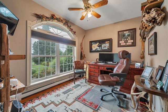 office featuring ceiling fan, hardwood / wood-style floors, a healthy amount of sunlight, and a baseboard heating unit