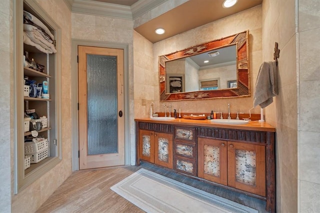 bathroom featuring hardwood / wood-style floors, vanity, tile walls, and ornamental molding