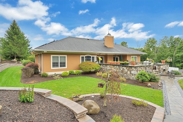 rear view of property featuring a lawn