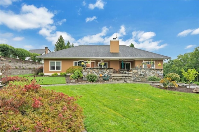 rear view of property featuring a lawn