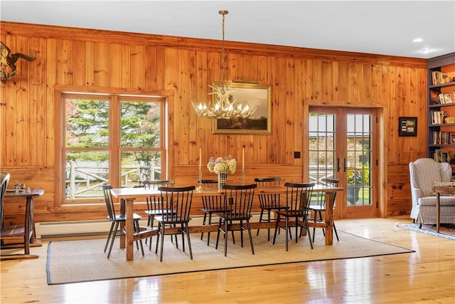 dining area with a wealth of natural light, light hardwood / wood-style flooring, and a chandelier