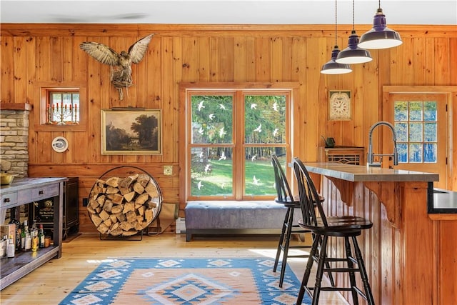 interior space featuring pendant lighting, wooden walls, and a wealth of natural light