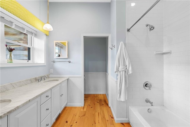 bathroom with vanity, wood-type flooring, and tiled shower / bath combo