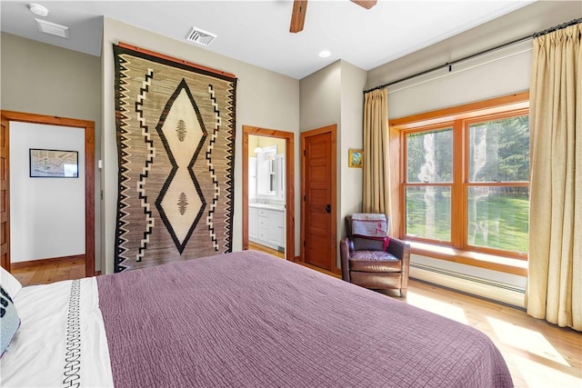 bedroom featuring ensuite bathroom, ceiling fan, light wood-type flooring, and a baseboard radiator