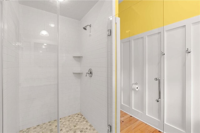 bathroom with hardwood / wood-style flooring and an enclosed shower