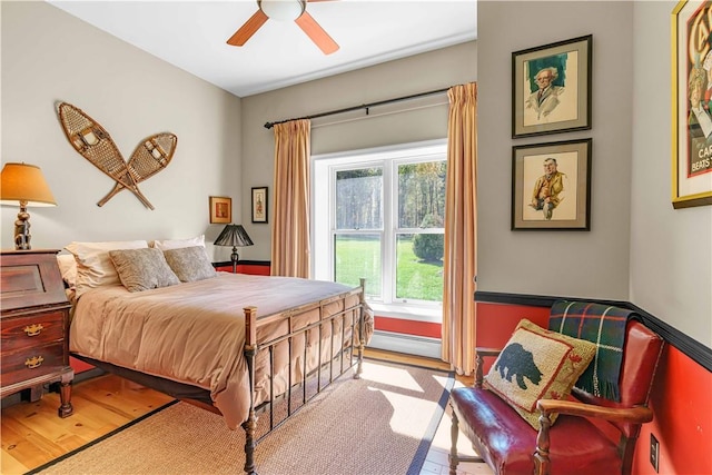 bedroom featuring light hardwood / wood-style floors, a baseboard radiator, and ceiling fan