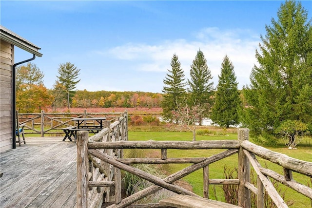 wooden terrace featuring a yard and a rural view