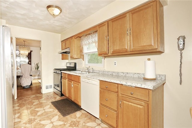 kitchen featuring sink, an inviting chandelier, light stone counters, white appliances, and light tile patterned floors