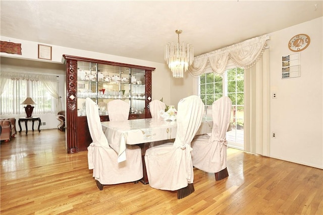 dining space with an inviting chandelier and hardwood / wood-style flooring