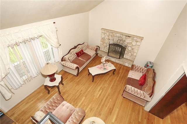 living room featuring a fireplace, hardwood / wood-style flooring, and vaulted ceiling