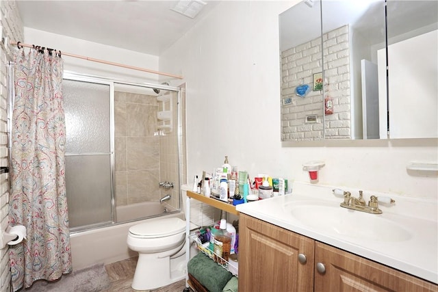 full bathroom featuring vanity, toilet, and combined bath / shower with glass door