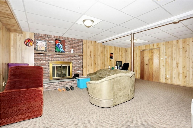 living room featuring wood walls, a fireplace, and carpet