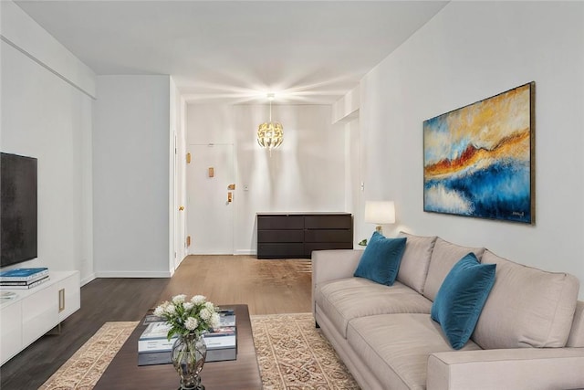 living room featuring dark hardwood / wood-style floors and an inviting chandelier