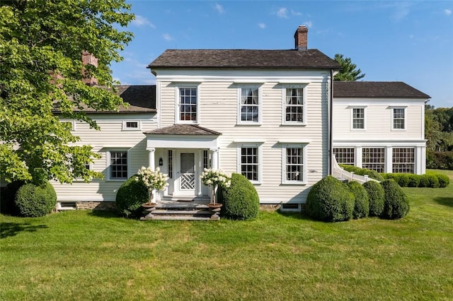 rear view of property featuring a lawn