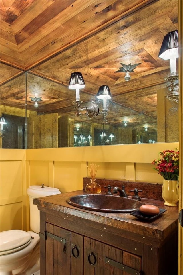 bathroom with vanity, toilet, and vaulted ceiling