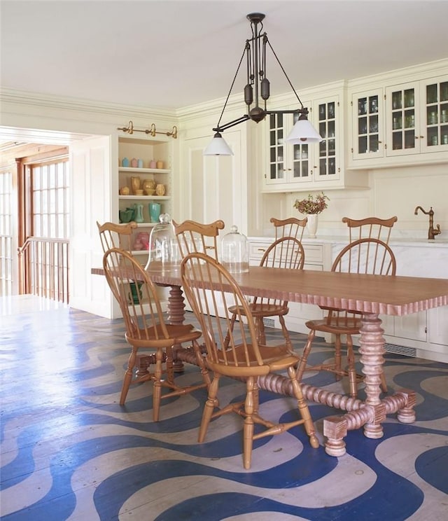 dining area featuring ornamental molding and an inviting chandelier