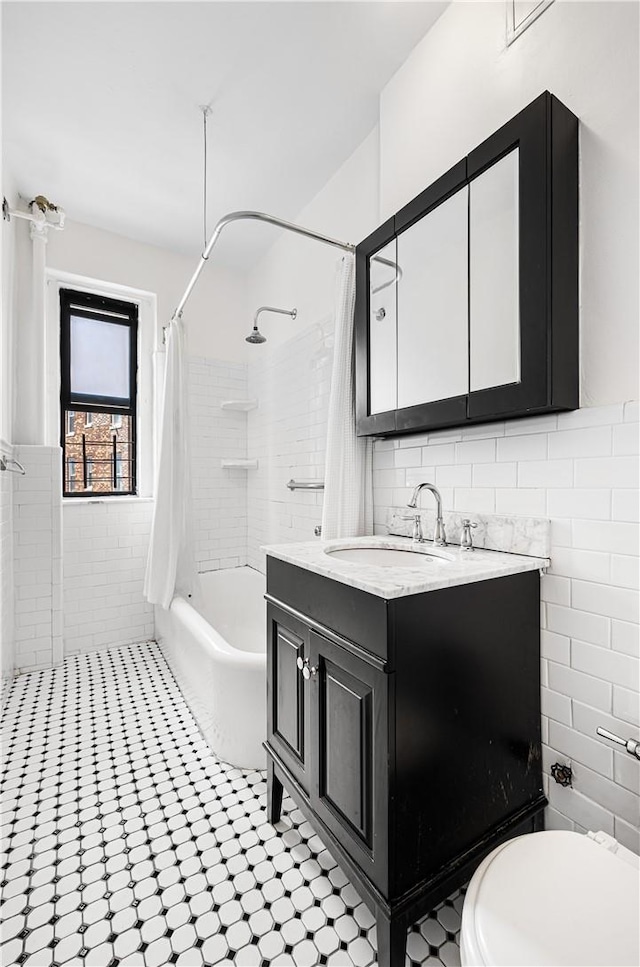 full bathroom with vanity, toilet, shower / bathtub combination with curtain, and tile walls