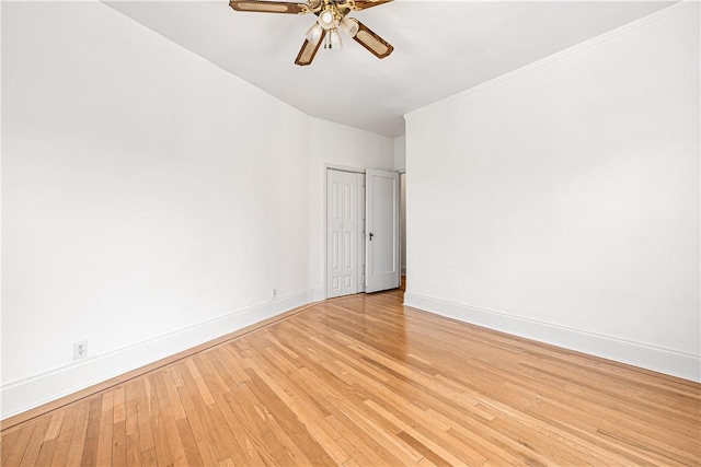 unfurnished room featuring ceiling fan, light wood-type flooring, and ornamental molding