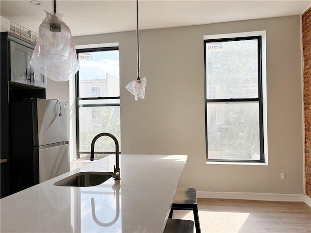 kitchen with stainless steel refrigerator, a wealth of natural light, and sink